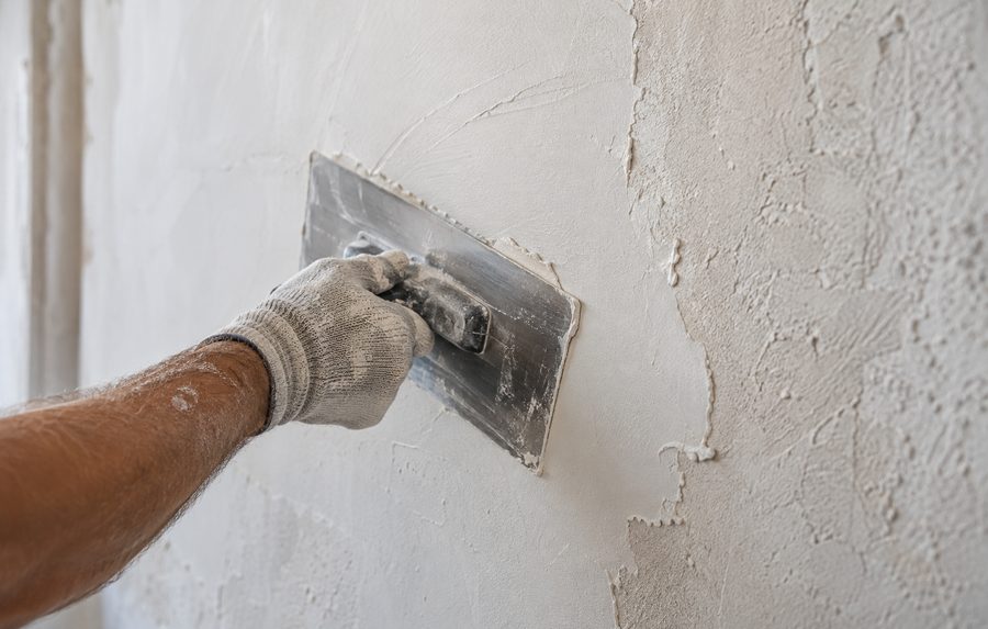 Application d'un enduit de lissage au platoir sur un mur intérieur avant peinture.